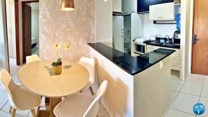 a kitchen with a small table and chairs in a kitchen at Vacanze - Barão de Mauá in Maceió