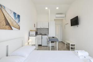 a white room with a bed and a kitchen at DIVA STUDIO PUNTA SKALA in Petrcane
