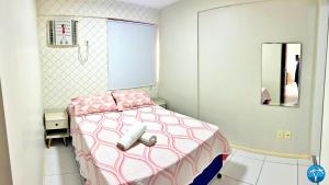 a small bedroom with a pink bed and a mirror at Vacanze - Barão de Mauá in Maceió +25 photos