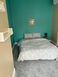 a blue bedroom with a bed with a blue wall at Grand appartement climatisé en plein centre de Bordeaux Place Fernand Lafargue in Bordeaux +2 photos
