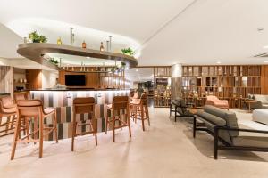 a restaurant with a bar with chairs and tables at Hotel Trianon Paulista in Sao Paulo