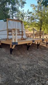 una panca di legno con una tenda sopra di Sendyeneh tent for 4 