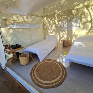 una camera con 2 letti e un tappeto in una tenda di Sendyeneh tent for 4 