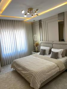 a bedroom with a large bed with white curtains at Luxury Apartment two bedroom - sea view - best spot in sousse in Sousse