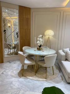 a dining room with a glass table and white chairs at Luxury Apartment two bedroom - sea view - best spot in sousse in Sousse