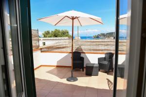 a patio with a table and an umbrella at Fantasy House Apartaments in Forio d'Ischia