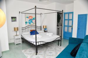 a bedroom with a canopy bed with a blue couch at Fantasy House Apartaments in Forio d'Ischia