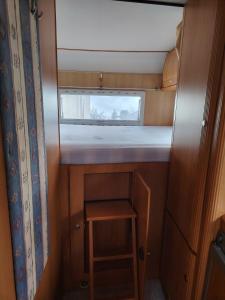 ein kleines Zimmer mit einem kleinen Tisch und einem Fenster in der Unterkunft Séjour insolite Camping-car fixe in Marennes