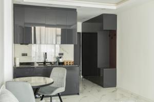 une cuisine avec une table et des chaises dans une pièce dans l'établissement GG LuxLiving at Panorama Beach, à Batoumi