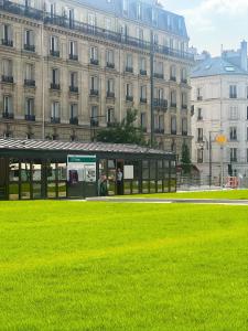a bus stop in front of a large building at L Écrin de Neuilly - La Défense & Champs Elysées 10 min away in Neuilly-sur-Seine