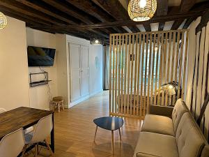 a living room with a couch and a table at Au petit Paris - Centre Ville in Auxerre