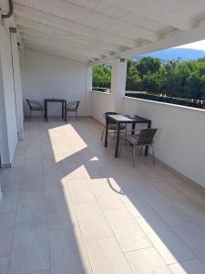 a patio with two tables and chairs on a balcony at Studio Apartments Trio in Šmrika