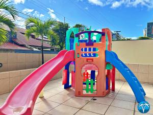 a playground with a slide on a patio at Vacanze - Barão de Mauá in Maceió