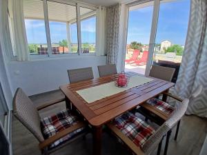 drewniany stół i krzesła w pokoju z oknem w obiekcie Apartment ANTONELLA w Nin