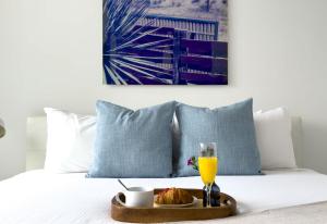 a tray of food and a glass of orange juice on a bed at suite with amazing bayfront views in Miami