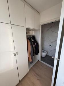 a walk in closet with white cabinets at TML 500m Luxurieus Penthouse 2 balconys in Boom