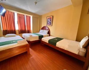 a hotel room with two beds and a window at Hotel San Eduardo in Chiclayo +2 photos