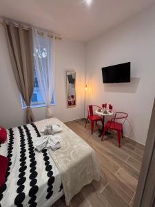 a bedroom with a bed and a table with chairs at La Rubis in Narbonne