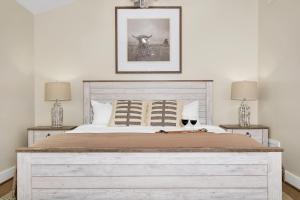 une chambre avec un grand lit blanc avec deux lampes dans l'établissement Main Street Retreat #14 - King Bed, On Main St, Shared Hot Tub & Pool, à Fredericksburg 13 autres photos