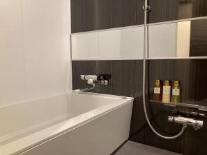 a bath tub in a bathroom with bottles of wine at SA Inn Ina Nice Road - Vacation STAY 31748v in Ina