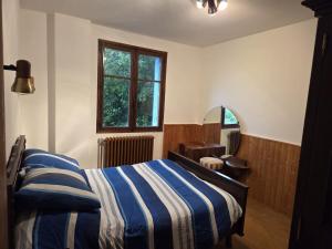 une chambre avec un lit avec une couverture rayée bleue et blanche dans l'établissement Appartement à la montagne, à Saint Firmin