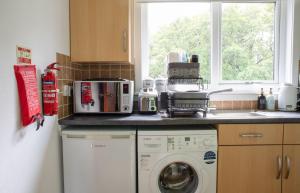 a kitchen with a washing machine and a window at Sorley's House in Stenscholl
