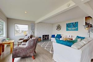 a living room with a white couch and a fireplace at Gracie's Sea View in Depoe Bay
