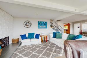 a living room with a white couch and blue pillows at Gracie's Sea View in Depoe Bay