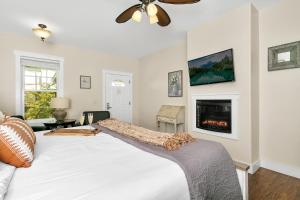 a bedroom with a white bed and a fireplace at Main Street Retreat #22 - King Bed, On Main St, Shared Hot Tub & Pool in Fredericksburg