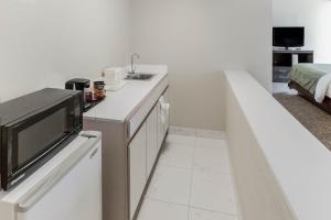 a small white kitchen with a sink and a microwave at Quality Inn & Suites Plattsburgh in Plattsburgh