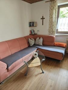 a couch in a living room with a cross on the wall at Landhaus Anni in Steingädele