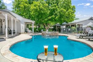 Dos vasos de cerveza sentados en una mesa en una piscina en Main Street Retreat #16 - King Bed, On Main St, Shared Hot Tub & Pool, en Fredericksburg