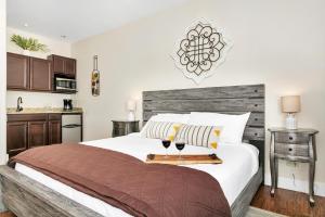 1 dormitorio con 1 cama y 2 copas de vino en Main Street Retreat #16 - King Bed, On Main St, Shared Hot Tub & Pool, en Fredericksburg