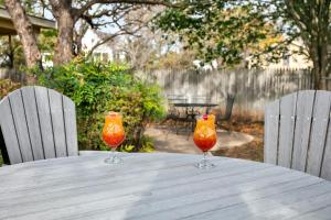 two orange glasses sitting on a wooden table at Main Street Retreat #2 - King Bed, On Main St, Shared Hot Tub & Pool in Fredericksburg +14 photos