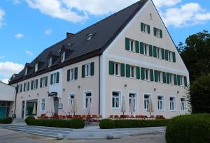 un grand bâtiment blanc avec un toit noir dans l'établissement Hotel-Gasthof-Kohlmeier, à Kranzberg