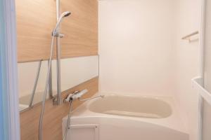 a bathroom with a white sink and a wooden floor at Pin pon hotel & cabin Tokuyama Ekimae - Vacation STAY 30945v in Shunan +4 photos