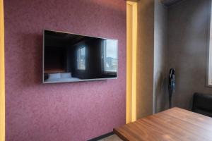 a flat screen tv hanging on a wall at Pin pon hotel & cabin Tokuyama Ekimae - Vacation STAY 30945v in Shunan