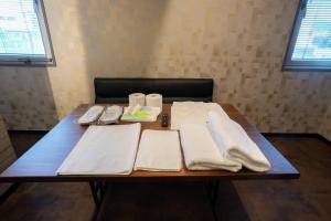 a table with white towels on top of it at Pin pon hotel & cabin Tokuyama Ekimae - Vacation STAY 30945v in Shunan
