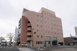a large building with a curving facade on a street at Pin pon hotel & cabin Tokuyama Ekimae - Vacation STAY 30945v in Shunan