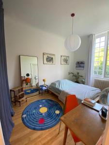 a bedroom with a large blue rug on the floor at Appartement avec jardin dans un château in Lissieu