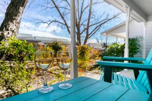 two glasses of white wine sitting on a blue table at Main Street Retreat #9 - King Bed, On Main St, Shared Hot Tub & Pool in Fredericksburg