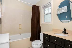 a bathroom with a toilet and a sink and a mirror at Main Street Retreat #9 - King Bed, On Main St, Shared Hot Tub & Pool in Fredericksburg +14 photos