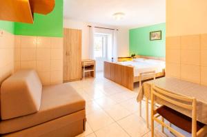 a room with a bed and a table in a room at Apartmani Fanuko in Čižići
