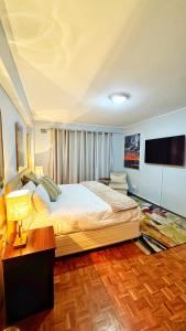 a bedroom with a large bed and a flat screen tv at HOPE-always in Cape Town