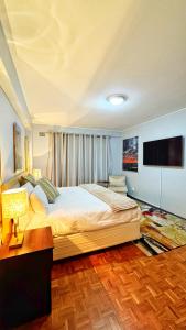 a bedroom with a large bed and a flat screen tv at HOPE-always in Cape Town