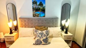a bedroom with a bed with two lamps and two mirrors at HOPE-always in Cape Town +37 photos