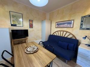 a living room with a blue couch and a table at Porto Rotondo-Centro, 12 minuti a piedi dalla Spiaggia Ira in Porto Rotondo +34 photos