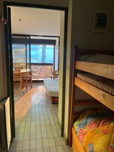 a room with bunk beds and a dining room with a table at Studio cabine - proche plage - parking - wifi in Le Grau-du-Roi