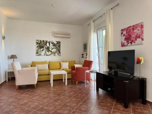 a living room with a yellow couch and chairs at Magic Sea View - Golden Beach in Skala Potamias