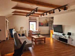 a living room with a couch and a tv at Pensjonat Stary Spichlerz in Ełk